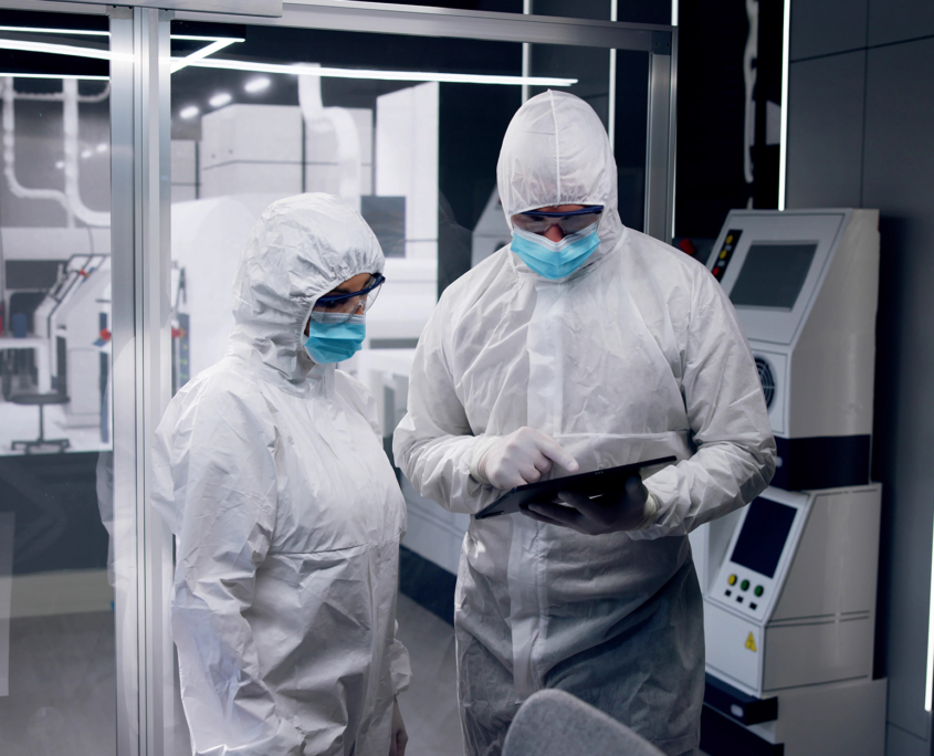 Two Workers Looking At Tablet In Semiconductor Manufacturing