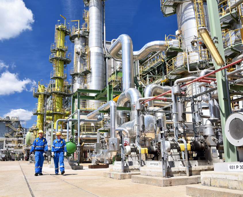 Two workers walking through refinery Two Workers Walking Through Refinery