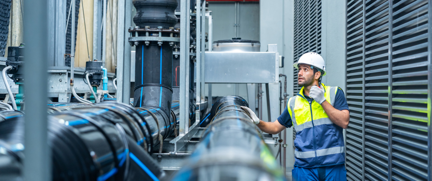 Worker Inspecting Chemical Plant Pipes