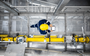 Worker With Tablet Walking Through Refinery